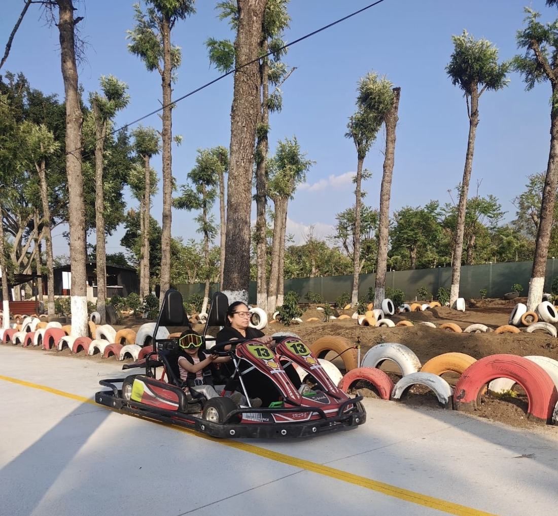 Niño conduciendo kart doble con acompañante